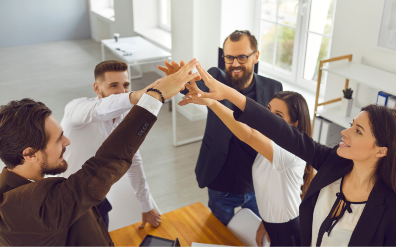 groupe de personnes se tenant les mains en l'air